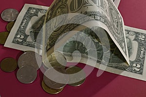 Banknotes and coins on red background.